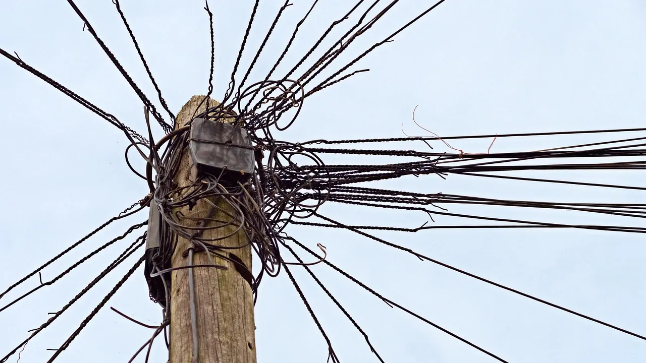 Poteau électrique d'où partent des dizaines de fils emmêlés