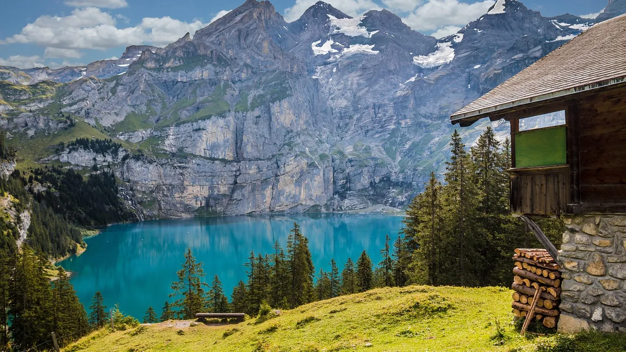 Chalet de bois au bord d'un lac de montagne turquoise dans les Alpes